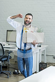 Businessman with cardboard box in hand quitting job