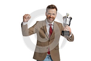 Excited businessman celebrating success with his cup in the air