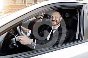 Excited businessman driving car to airport, going on business trip