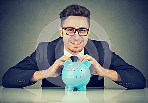 Excited businessman with funds in piggy bank