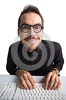 Excited businessman with glasses typing on keyboard