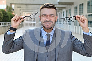 Excited businessman holding two pair of eyeglasses