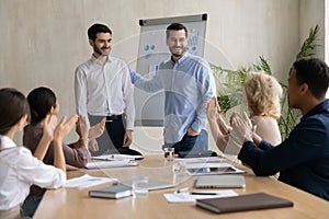 Excited businessman introduce male newcomer at office meeting