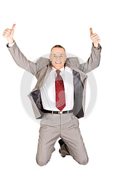 Excited businessman jumping with ok sign