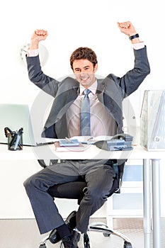 Excited businessman in office rejoicing success