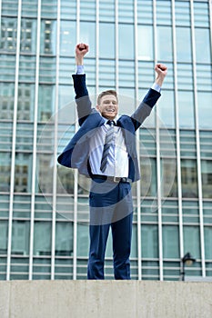 Excited businessman raising his arms