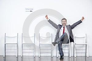 Excited businessman sitting and waiting for interview in office