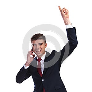 Excited businessman speaking on the phone is celebrating