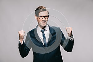 Excited businessman in suit celebrating victory isolated