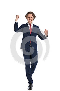 Excited businessman in suit with fist up celebrating the winning