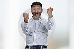 Excited businessman winner celebrating success with clenched fists.