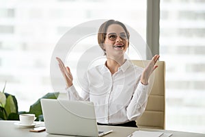 Excited businesswoman raising hands amazed or happy with great n