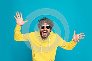 Excited casual man with moustache laughing and opening arms