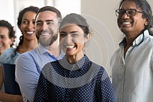 Excited cheerful diverse team of department employees standing together