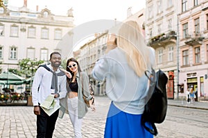 Excited cheerful mix raced couple, African man and Caucasian girl, enjoying walking outdoors, in the center of ancient