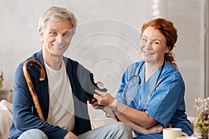 Excited cheery nurse reading mans blood pressure