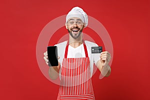 Excited chef cook or baker man in striped apron t-shirt toque chefs hat isolated on red background. Cooking food concept