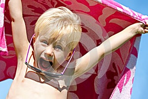 Excited Child in Beach Towel on Summer Day photo