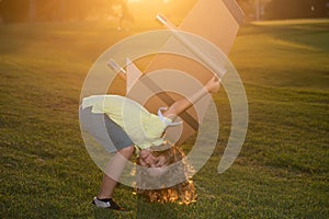 Excited child boy dreams and travels. Boy with airplane toy outdoors. Happy child playing with toy airplane outdoors in