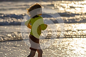 Excited child playing in the sea. Kid having fun outdoors. Summer vacation and healthy lifestyle concept. Cute kids