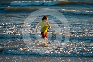 Excited child playing in the sea. Kid having fun outdoors. Summer vacation and healthy lifestyle concept. Cute kids