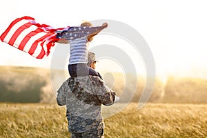 Excited child sitting with american flag on shoulders of father reunited with family