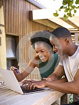 Excited Couple With Credit Card Using Laptop At Home To Book Holiday Or Shop Online