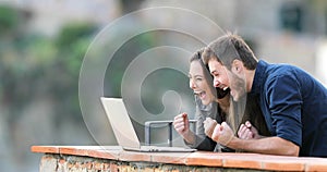 Excited couple finding online content in a laptop