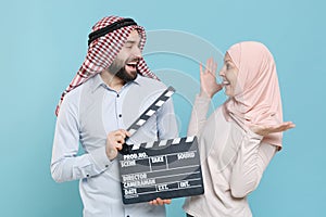 Excited couple friends arabian muslim man wonam in keffiyeh kafiya ring igal agal hijab clothes isolated on blue wall