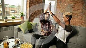 Excited couple, friends watching sport match, championship at home