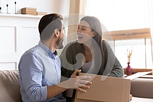 Excited couple have fun unboxing parcel with internet order photo