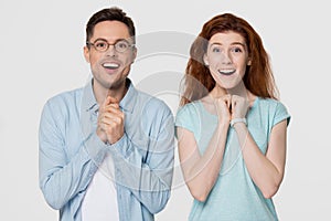 Excited couple looking at camera with delight isolated on background