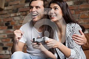 Excited couple playing computer video games together