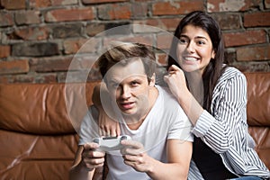 Excited couple playing video games together at home