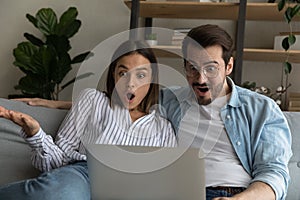 Excited couple shocked by amazing sale deal on laptop