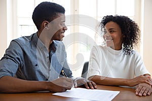 Excited couple sign agreement at realtor office