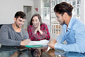 Excited couple signing contract for own house