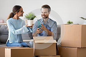 Excited couple unpack boxes sitting on couch