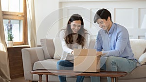 Excited couple unpacking internet postal order package together