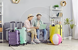 Excited couple using laptop to book tickets and hotel online, preparing for vacations.