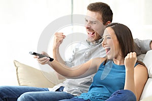 Excited couple watching tv on couch