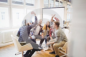 Excited creative business people giving high-five