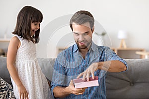 Excited dad open gift box from cute preschooler daughter