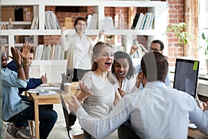 Excited diverse business team employees screaming celebrating good news success