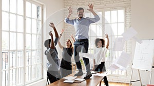 Excited diverse colleagues have fun celebrate business success