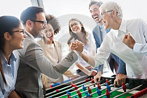 Excited diverse employees enjoying funny activity at work break, creative friendly workers play game
