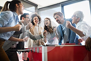 Excited diverse employees enjoying funny activity at work break, creative friendly workers play game