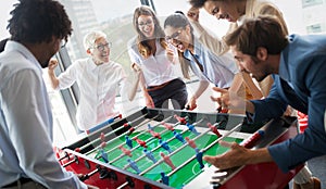 Excited diverse employees enjoying funny activity at work break, creative friendly workers play game