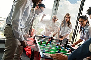 Excited diverse employees enjoying funny activity at work break, creative friendly workers play game