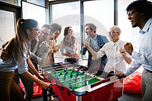 Excited diverse employees enjoying funny activity at work break, creative friendly workers play game